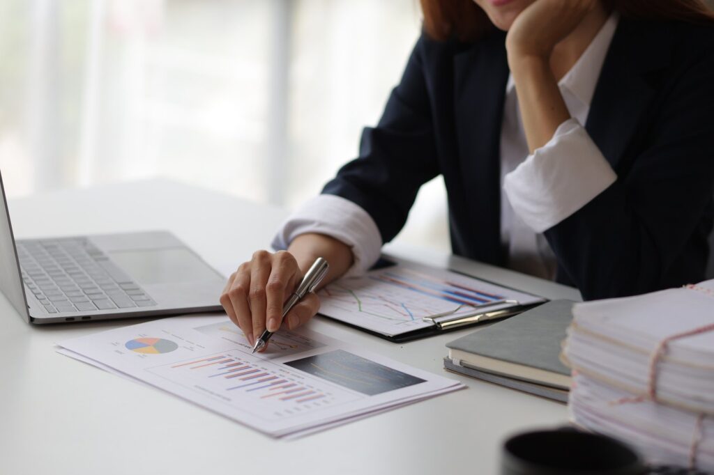 Business woman at office desk analyzing financial data and planning investment investments.